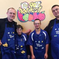 Braylon poses for a photo at Cora's restaurant for a Cops and Crepes event with another officer and two Special Olympics athletes