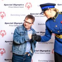 Kristi MacKay, dressed in her uniform, fist bumps an athlete at an event.