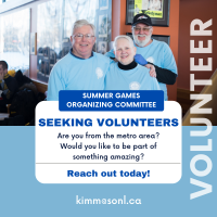 Three smiling volunteers wearing blue shirts.