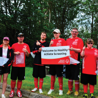 Special Olympics athletes and volunteers holding a sign saying Welcome to Healthy Athletes Screenings