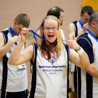 SOBC athlete Kathleen Fisher holding medal with thumbs up and smiling