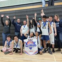 Port Moody Secondary student-athletes celebrating their first-place finish holding up their medals and banner