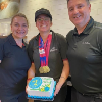 Marley Gayler poses with her managers at Tim Hortons, proudly wearing her Special Olympics medals. 