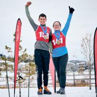 Two SOBC athletes on podium with arms raised