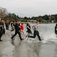 Participants running into cold waters 