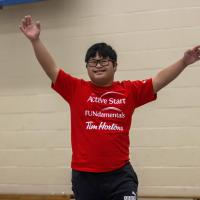 SOBC youth participant raising arms and smiling