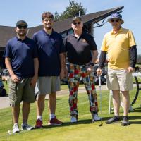 Group photo of two SOBC athletes and two golfers at a golf course