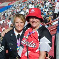 A police officer poses for a photo with an athlete