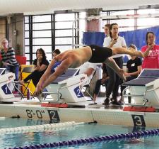 SOBC athlete in mid air diving from the starting block into the pool.