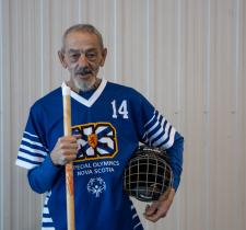 Richard Myette poses with his floor hockey stick looking into the camera