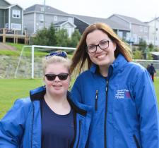 Volunteer Melissa Tobin smiles for a photo with an athlete on a soccer field.