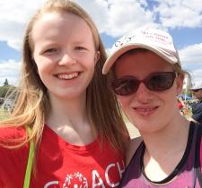 A young volunteer takes a selfie with an athlete on a sunny day