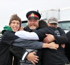 Sgt. Joe Tataryn in his police uniform as Special Olympics athletes give him a group hug.