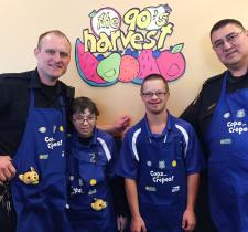 Braylon poses for a photo at Cora's restaurant for a Cops and Crepes event with another officer and two Special Olympics athletes