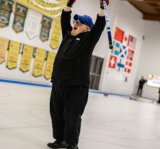 Curling athlete celebrates with both arms in the air