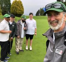 Drew group selfie with four golf athletes on golf course