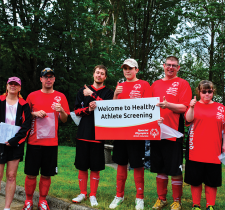 Special Olympics athletes and volunteers holding a sign saying Welcome to Healthy Athletes Screenings