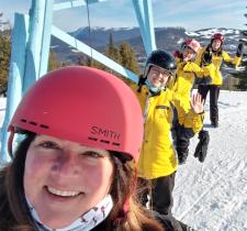 Selfie of Misty and three skiing athletes waving behind her