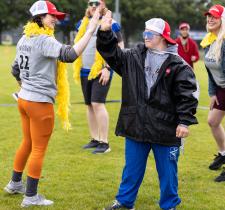 SOBC athlete high fiving motionball participant wearing colorful costume