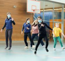 Youth participants jumping sideways and smiling