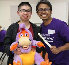 SOBC athlete Abraham Wong with dental care professional, holding a stuffed animal and tooth brush