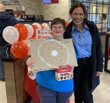 Danielle holding Choose To Include poster with Tim Hortons employee