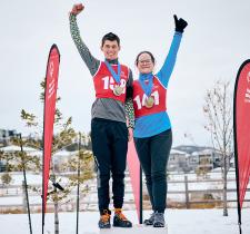 Two SOBC athletes on podium with arms raised