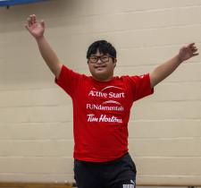 SOBC youth participant raising arms and smiling