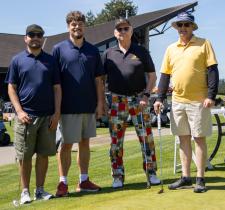 Group photo of two SOBC athletes and two golfers at a golf course