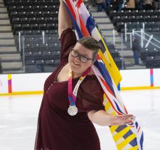 Kari Trott with silver medal, holding flag