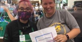 Sheenagh holding up #IChooseToInclude sign with Thrifty Foods employee