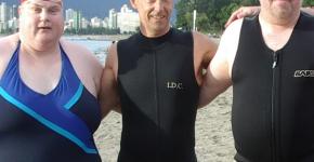 Peter with two other SOBC athletes, all in swimsuits at beach in Vancouver