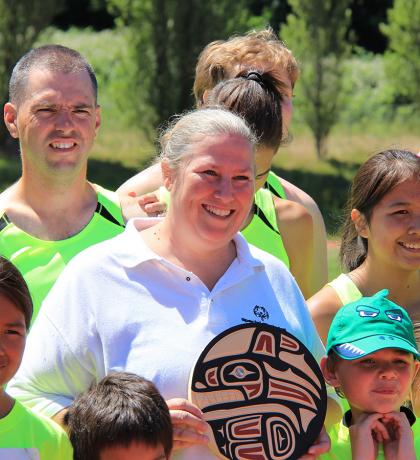 Angela Behn receiving the 2019 SOBC Howard Carter Award surrounded by athletes at the SOBC - Nanaimo athletics meet on June 15.