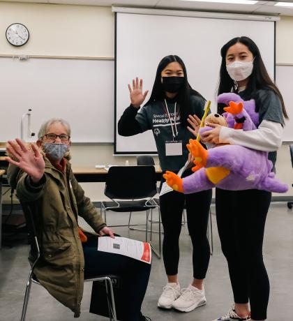 A Special Olympics athlete and volunteers wave at a Healthy Athletes screening