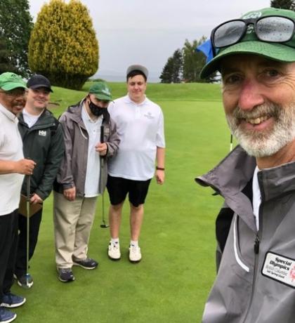 Drew group selfie with four golf athletes on golf course