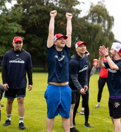 motionball athlete celebrating with hands in air with teammates cheering