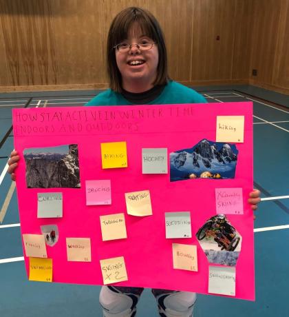 Claire Lemaire holding up poster that describes ways to stay active in the winter