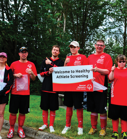 Special Olympics athletes and volunteers holding a sign saying Welcome to Healthy Athletes Screenings