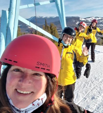 Selfie of Misty and three skiing athletes waving behind her