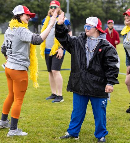 SOBC athlete high fiving motionball participant wearing colorful costume