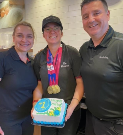Marley Gayler poses with her managers at Tim Hortons, proudly wearing her Special Olympics medals.