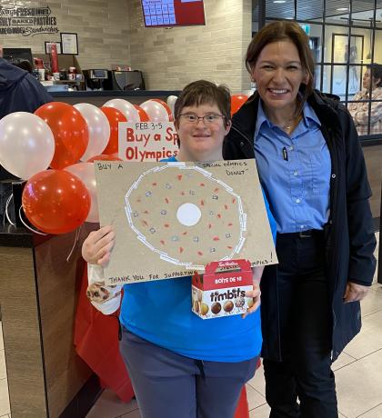 Danielle holding Choose To Include poster with Tim Hortons employee