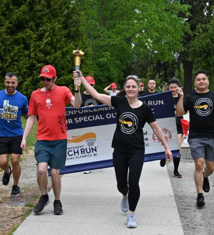 Law enforcement members and SOBC athletes running with LETR banner and torch