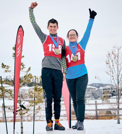 Two SOBC athletes on podium with arms raised