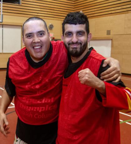 Two SOBC basketball players smiling and side-hugging