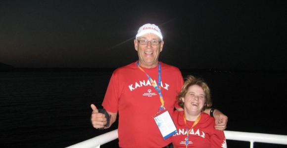 Gord Stewart poses on a boat with an athlete at World Games.