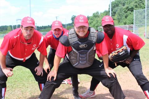 Softball players pose for photo