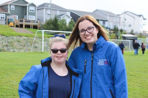 Melissa Tobin smiles for a photo with an athlete on a soccer field