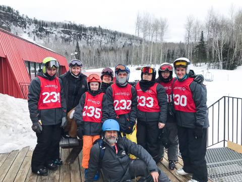 Special Olympics Alberta coach poses with his alpine ski team