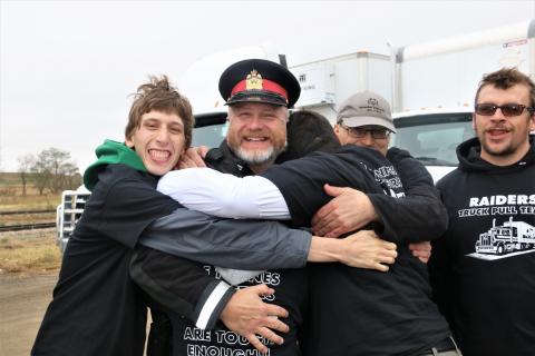 Sgt. Joe Tataryn in his police uniform as Special Olympics athletes give him a group hug.